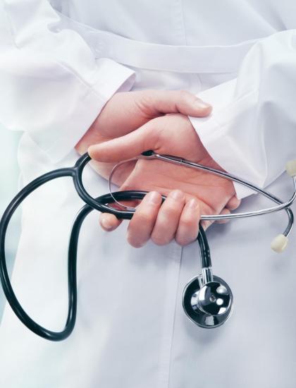 Medico in camice bianco con stetoscopio in mano.