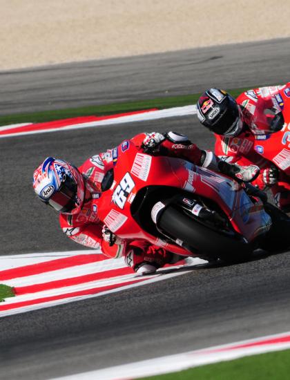 Due motociclisti in competizione su una pista durante una gara.