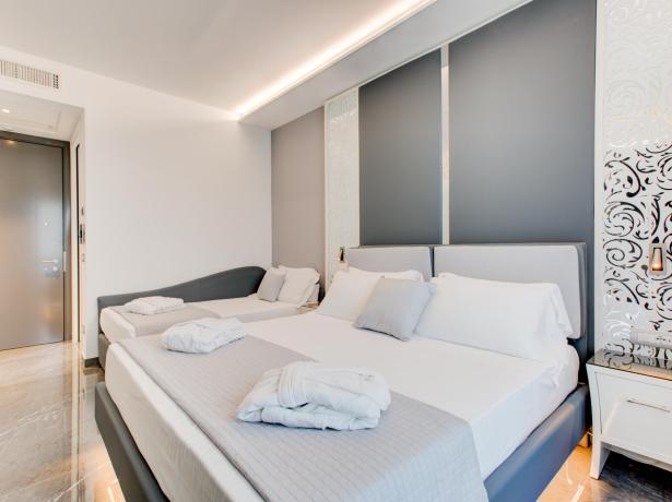 Camera moderna con letto matrimoniale, divano e decorazioni eleganti.