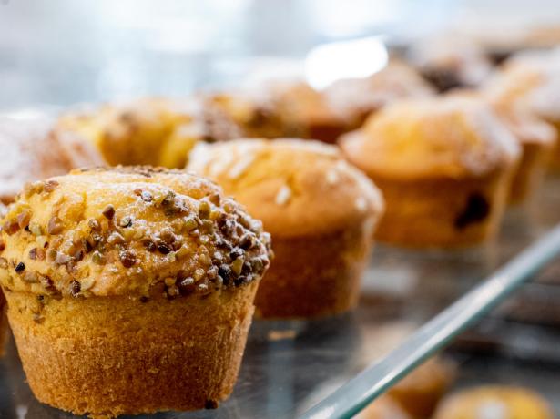 Fresh muffins with nut crumble on a tray.