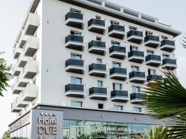 Hotel moderno con balconi, giardino e quattro stelle.
