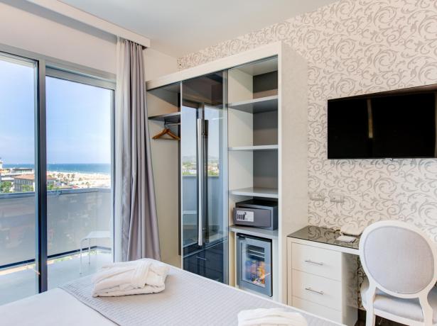 Camera d'hotel con vista mare, TV, cassaforte e minibar.