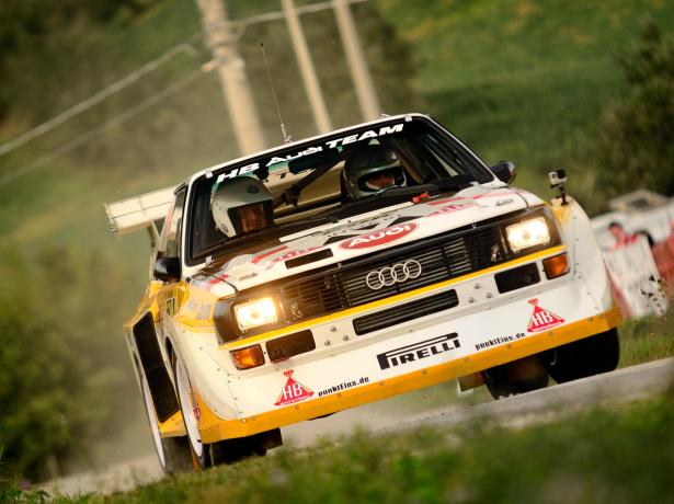 Audi rally car in action on a dirt road.