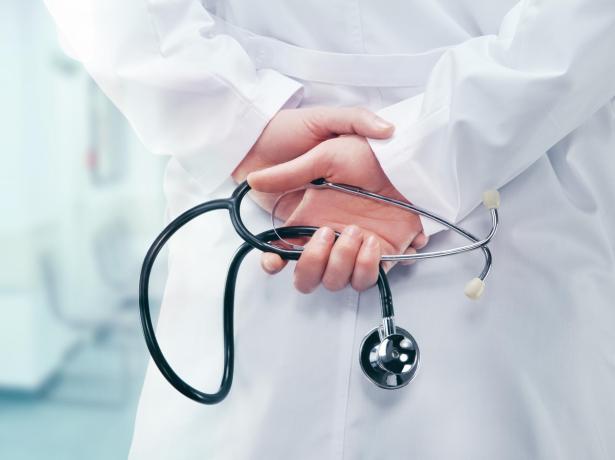 Medico in camice bianco con stetoscopio in mano.