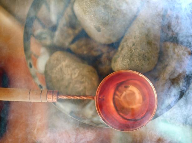 Copper bowl over hot stones, enveloped in steam.