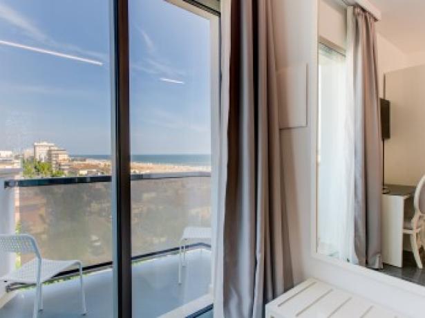 Room with sea view, balcony, and modern furnishings.