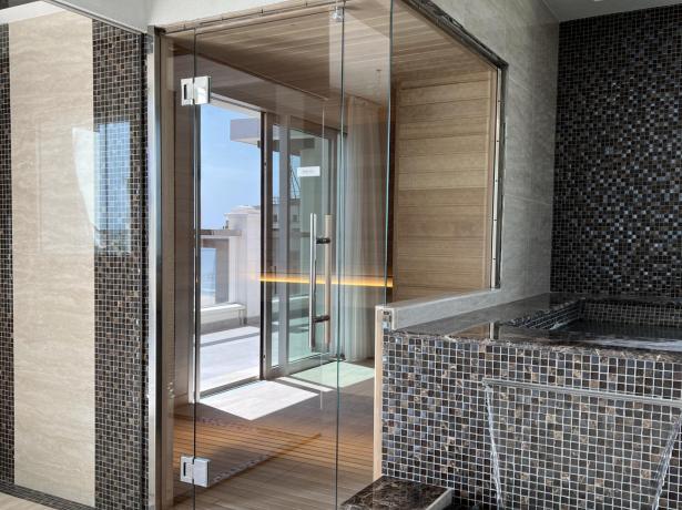 Modernes Badezimmer mit Sauna und schwarzem Mosaik.