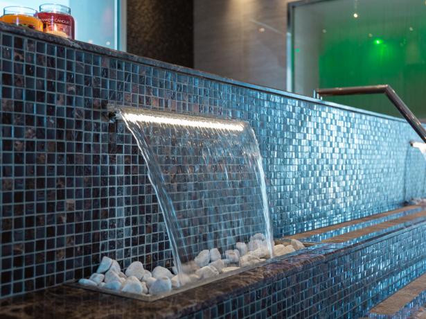 Modern fountain with tiles and scented candles.