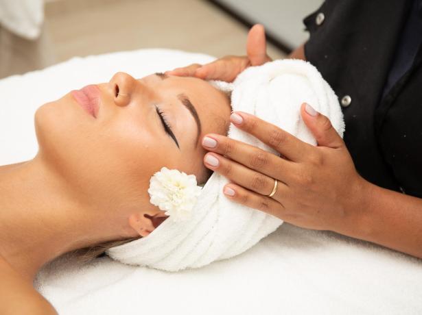 Woman receiving a relaxing massage with flower and towel.