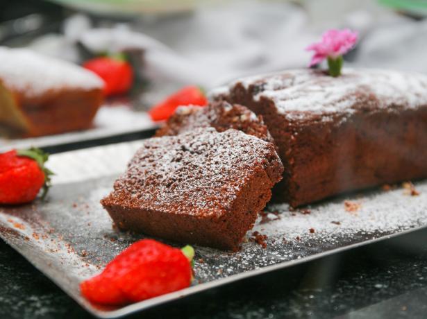 Chocolate cake with powdered sugar and fresh strawberries.