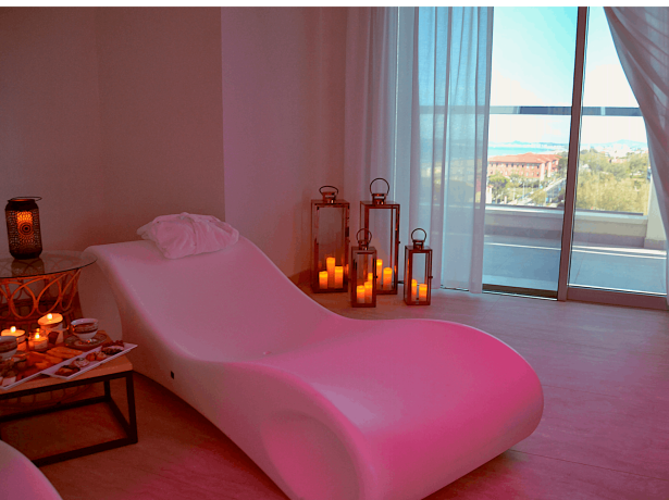 Una stanza relax con poltrona, candele e vista panoramica.