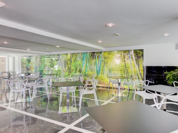 Sala da pranzo moderna con parete decorata a tema foresta.