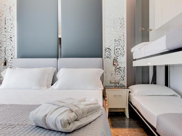Camera moderna con letto matrimoniale e letti a castello, decorazioni eleganti.