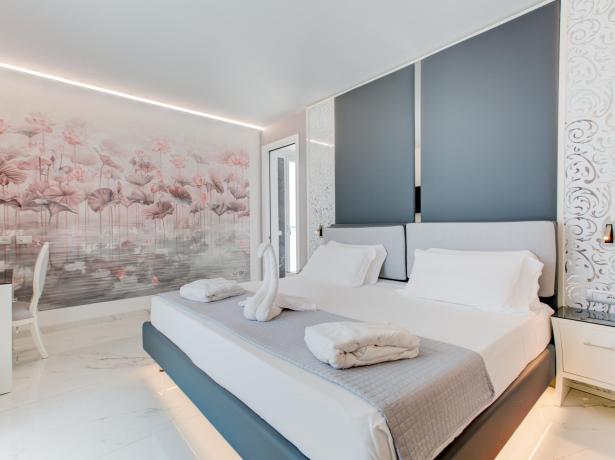 Camera elegante con letto matrimoniale e decorazioni floreali.